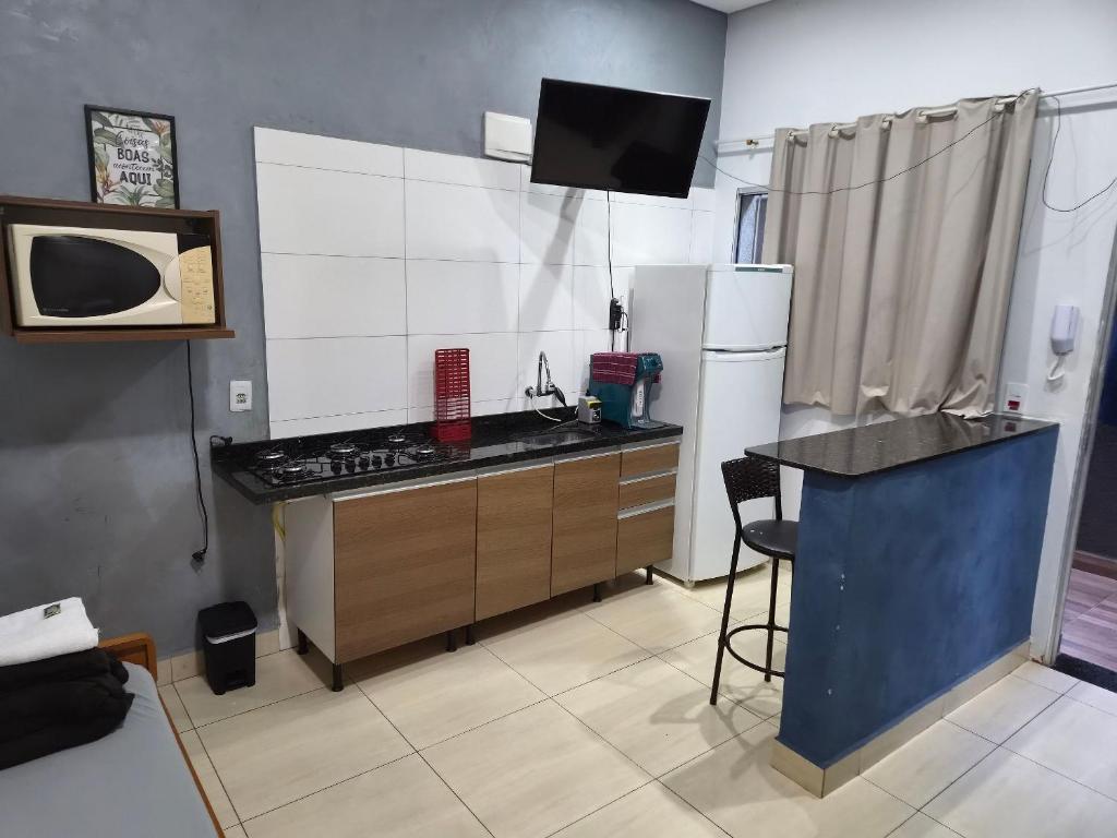 a kitchen with a stove and a refrigerator at loft 2 em Salto Acomoda até 4 pessoas rede urbana in Salto