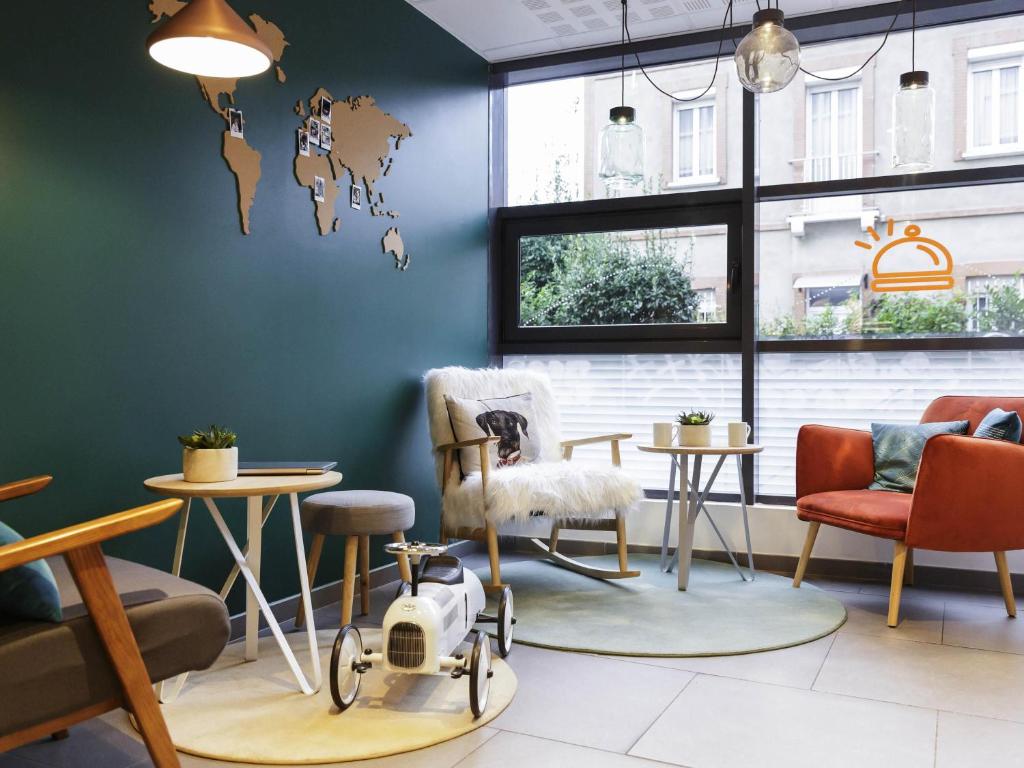 a room with chairs and tables and a world map on the wall at Aparthotel Adagio Access Toulouse St Cyprien in Toulouse