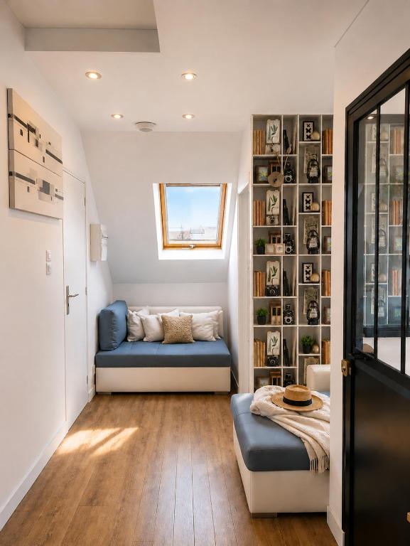 a living room with a blue couch and a book shelf at LES COQUILLAGES, plage et centre à pied, lits faits, 2 sdb in Berck-sur-Mer