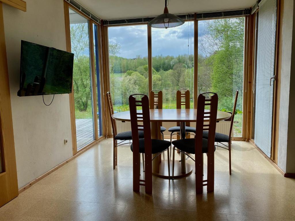 a dining room with a table and chairs and a large window at Apartment with Terrace & Garden View in Zwiesel