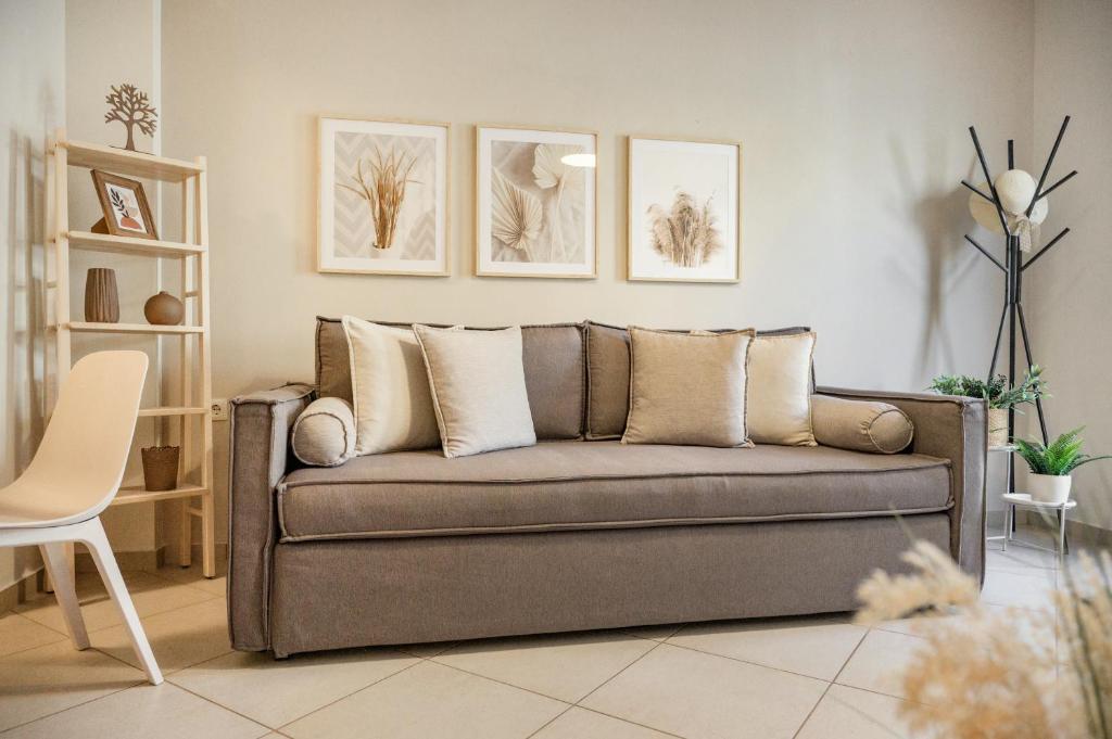 a living room with a couch and pictures on the wall at IFESTOS APARTMENTS in Ierissos