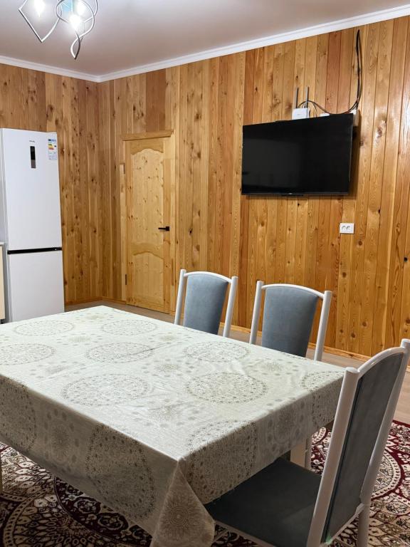 a kitchen with a table and chairs and a refrigerator at Kausar cottage in Cholpon-Ata