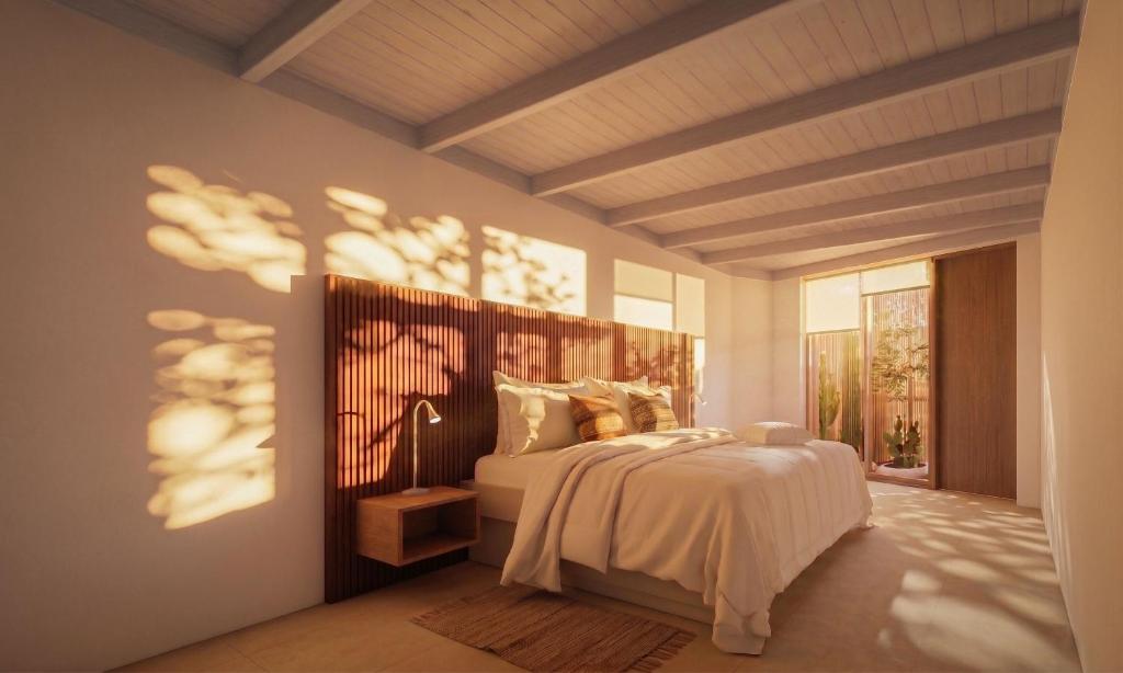 a bedroom with a bed and a lamp in it at Hotel Terrantai in San Pedro de Atacama