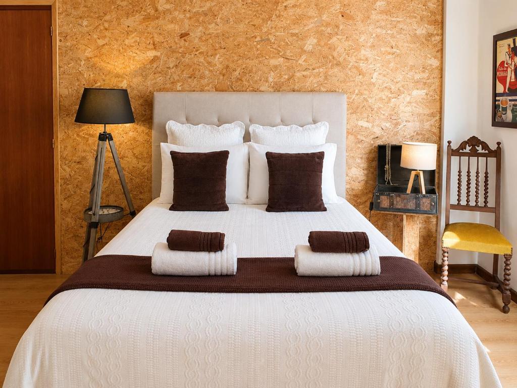 a bedroom with a large white bed with brown pillows at Casa do Criativo ® Bed&Breakfast in Almada