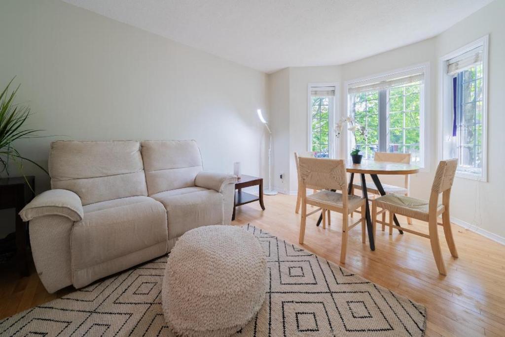a living room with a couch and a table and chairs at Pool, BBQ & Foosball Spacious 4BR Home in Gatineau