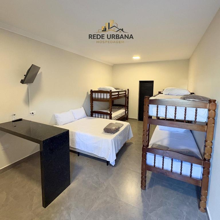 a room with two bunk beds and a desk at Loft 9 com ar-condicionado da Rede Urbana in Indaiatuba