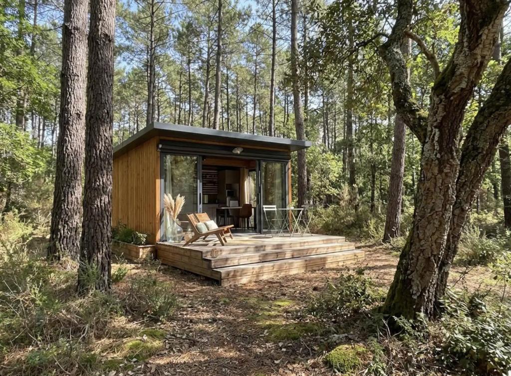 a tiny house in the woods with a deck at La forêt PALOMA, Ecolodge in Léon