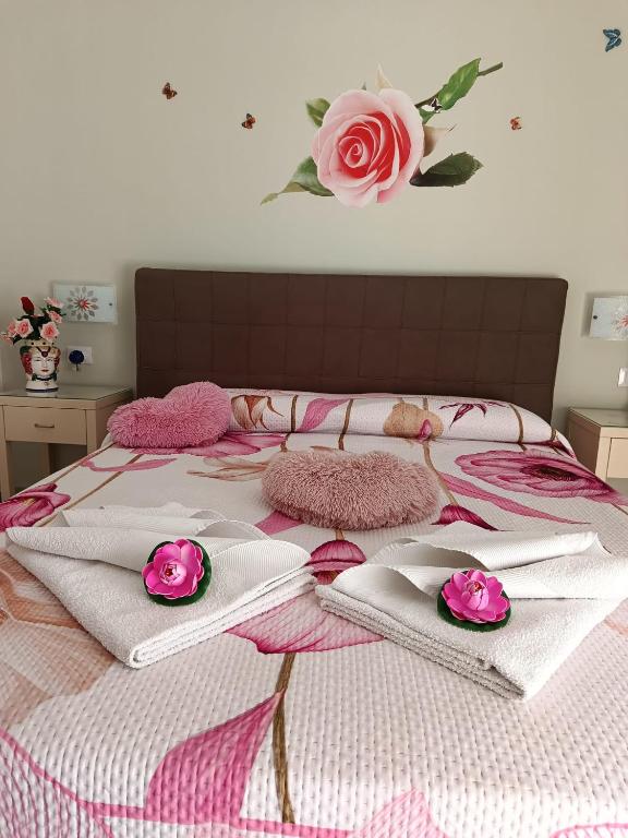 a bed with pink and white blankets and flowers on it at Al Punto Giusto in Catania