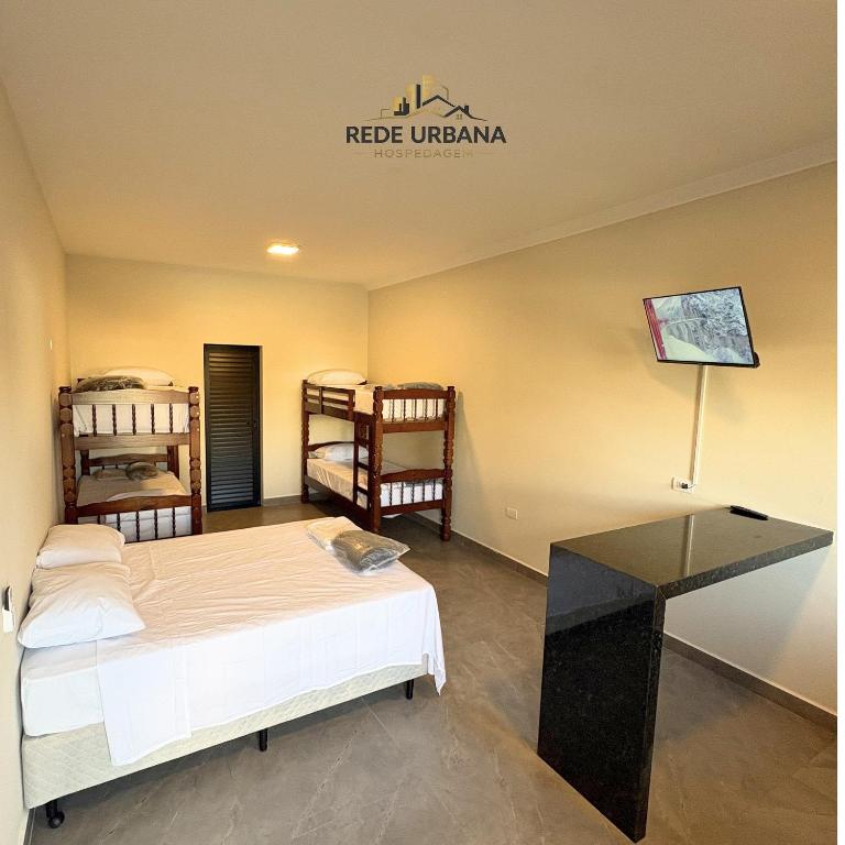 a room with a bed and a desk in it at Loft 10 com ar-condicionado da Rede Urbana in Indaiatuba