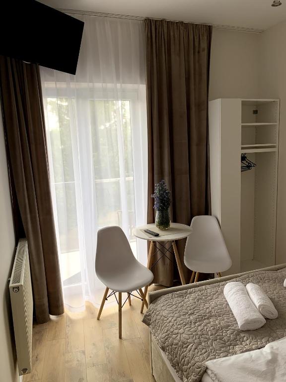 a bedroom with a bed and a table and a window at Na Rogu in Sandomierz