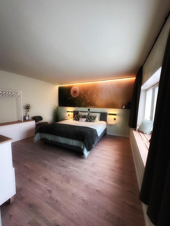 a bedroom with a bed and a wooden floor at Zaza Suites in Middelkerke