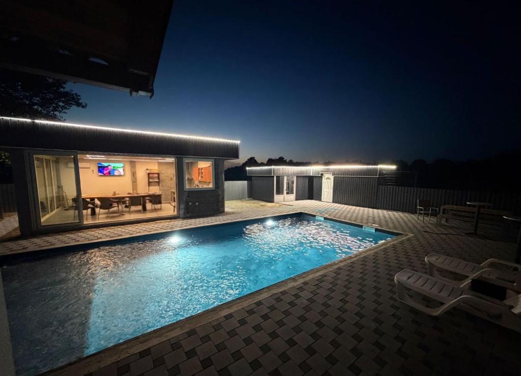 a swimming pool in a yard at night at Vikend Kuca Okanovic in Gradačac