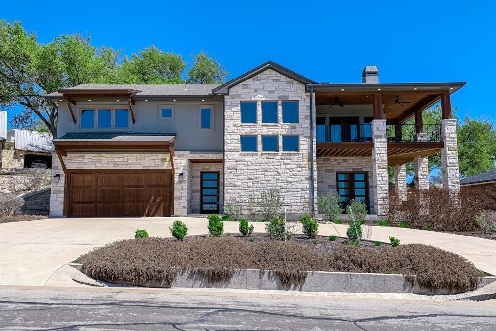 a large house with a garage at Bright & Spacious Family Home with Firepit, Lake Views, Furnished Deck, Free WiFi in Lago Vista