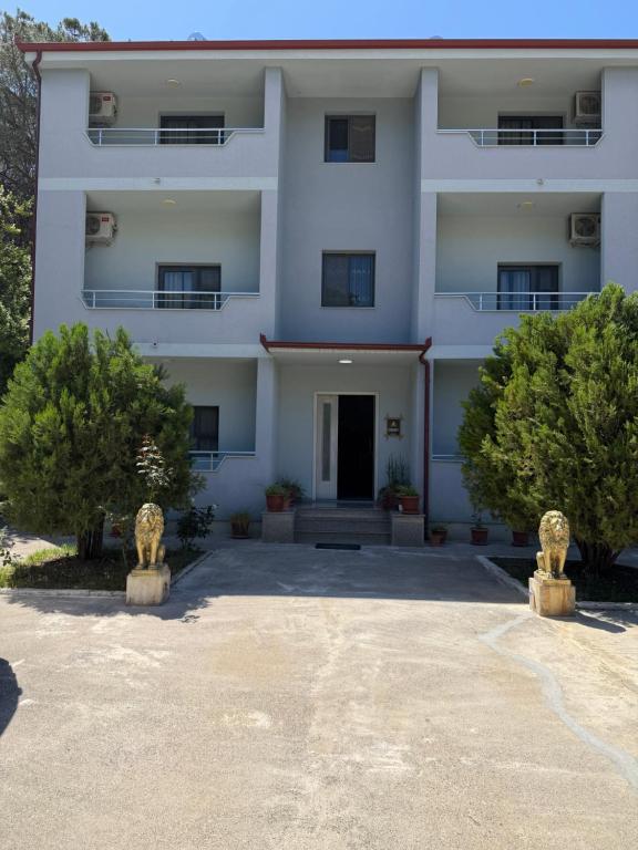 a white building with trees in front of it at Blue Shore in Golem
