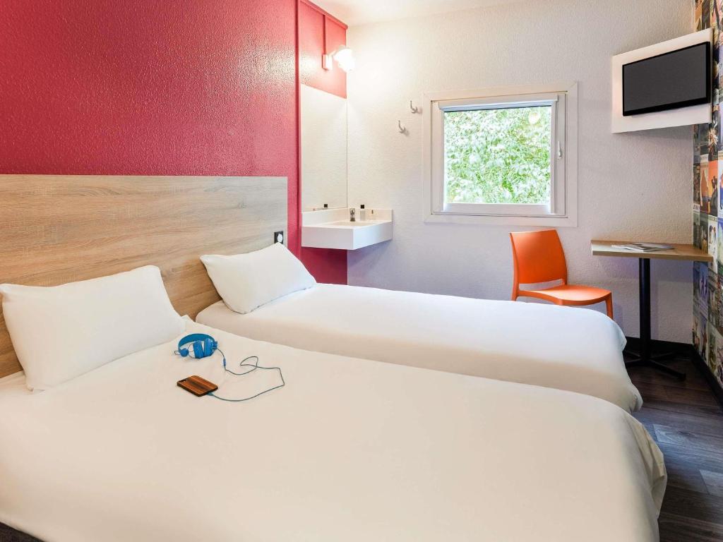 a hotel room with two beds and a sink at hotelF1 Evry A6 in Courcouronnes