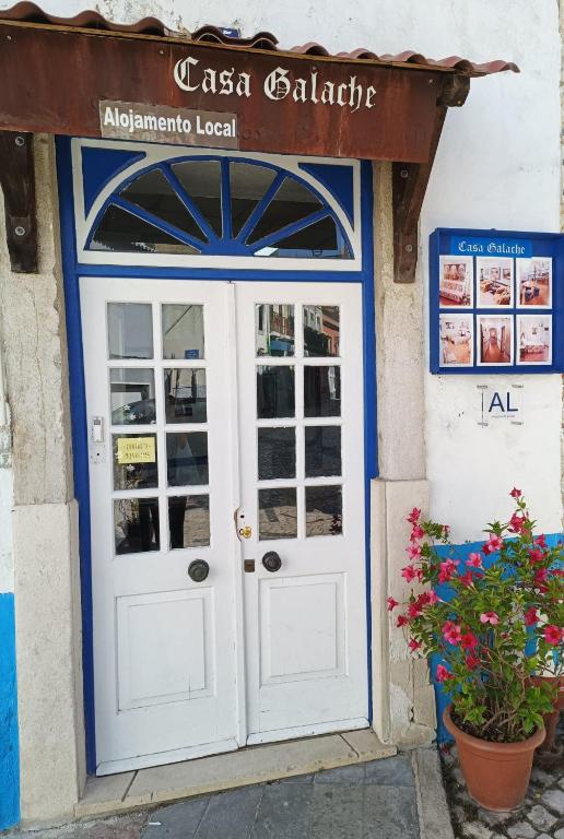 a door to a restaurant with flowers in front of it at Casa Galache in Vila Franca de Xira