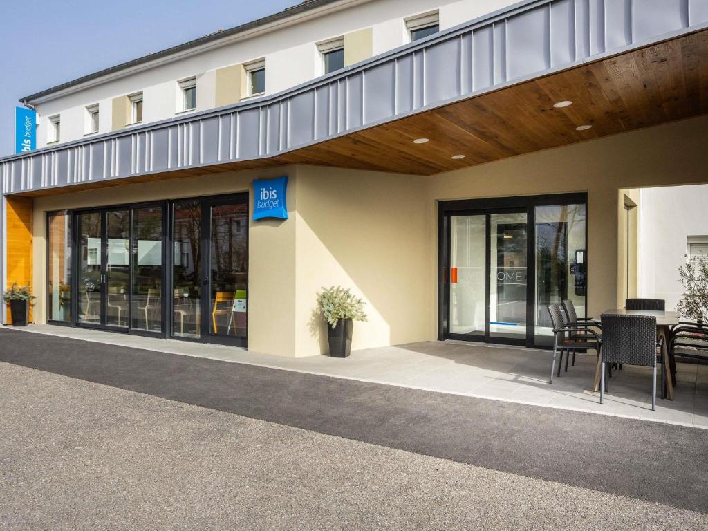 a building with a table and chairs in front of it at ibis budget Haguenau Strasbourg Nord in Haguenau