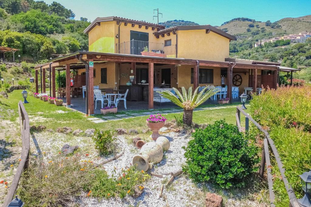 a house with a garden in front of it at Tra Cielo e Mare Rooms Rio Marina in Rio nellʼElba