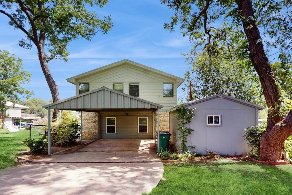 a house with a garage and a tree at Lakefront Home on Water with Great Views, Boat Dock, Al Fresco Dining, and WiFi in Kingsland