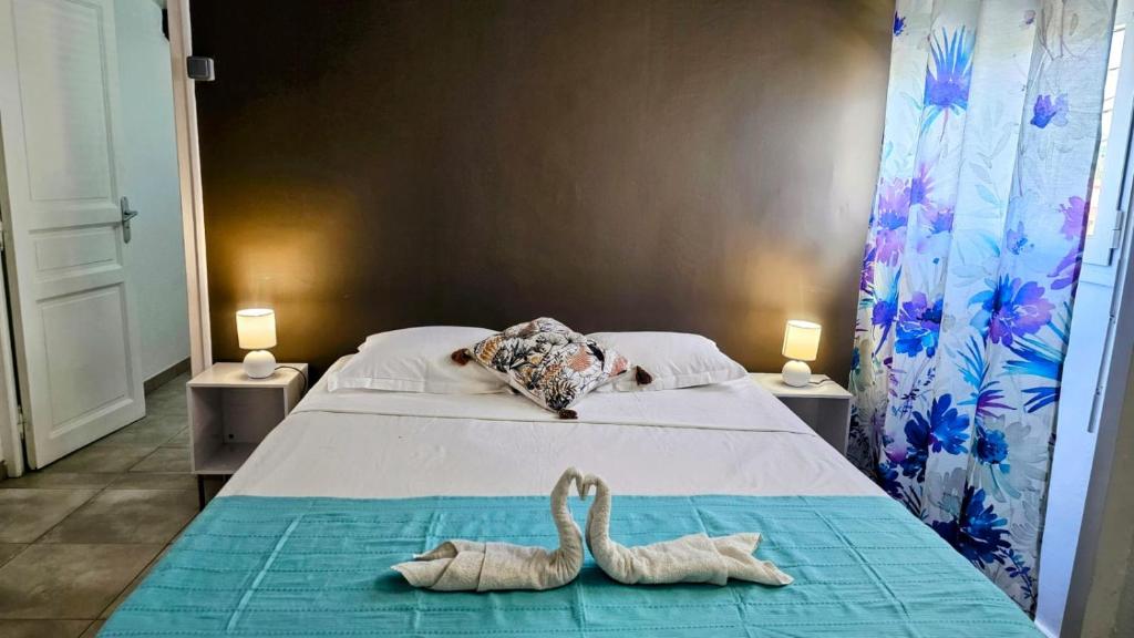 a bed with two animal towels on it at Les 2 Cocotiers - Maison d'hôtes d'Eugénie in Sainte-Luce