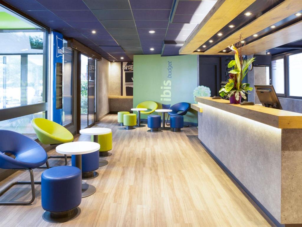 a waiting area with tables and chairs in a office at ibis budget Thonon Les Bains in Thonon-les-Bains