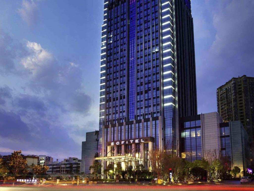 a large tall building with lights on it at Sofitel Kunming in Kunming