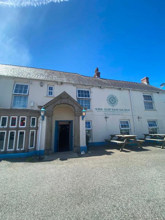 a white building with a blue door on the front at The Top House Inn in Lizard