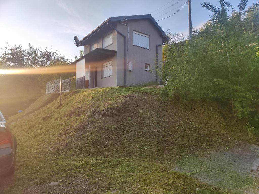 a house on a hill with a car parked in front at Imprezowy domek in Żeleźnikowa Wielka