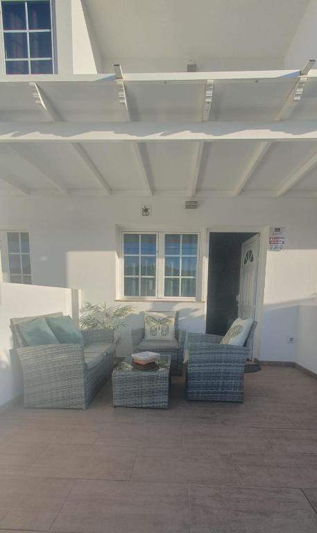 a living room with couches and chairs in a building at Volcán de la Corona House in Punta Mujeres