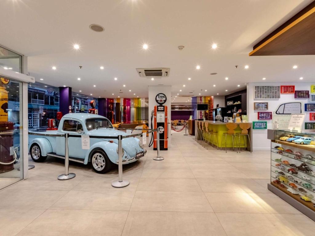 a store with an old car in the middle of it at Ibis Styles Balneário Camboriú - 1 Quadra do Mar in Balneário Camboriú