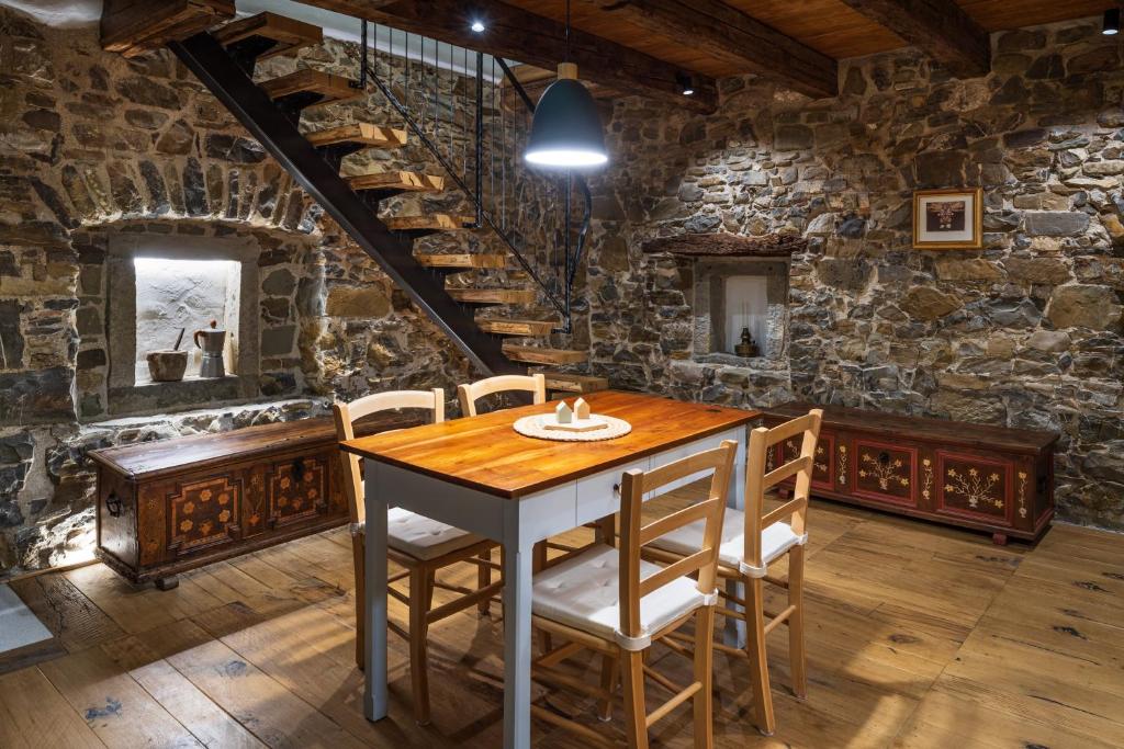 a dining room with a table and chairs in a stone wall at Vila Dobra in Dobravlje