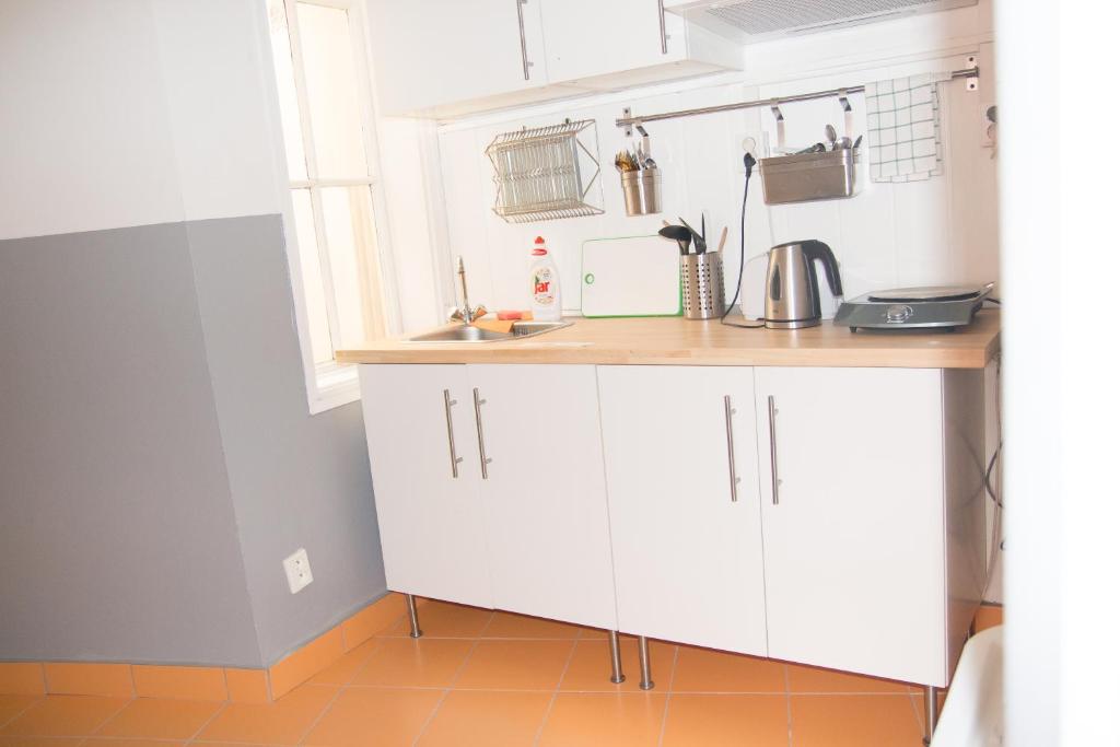 a kitchen with white cabinets and white appliances at Hostel Franz Kafka in Prague