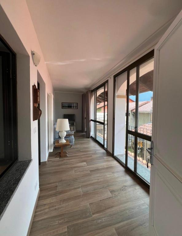 a hallway with a floor to ceiling window and a living room at Cà Dal Vindu in Biella