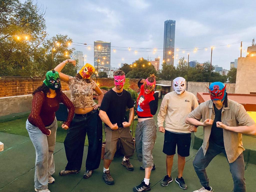 a group of people wearing masks posing for a picture at Nomaddicts in Mexico City