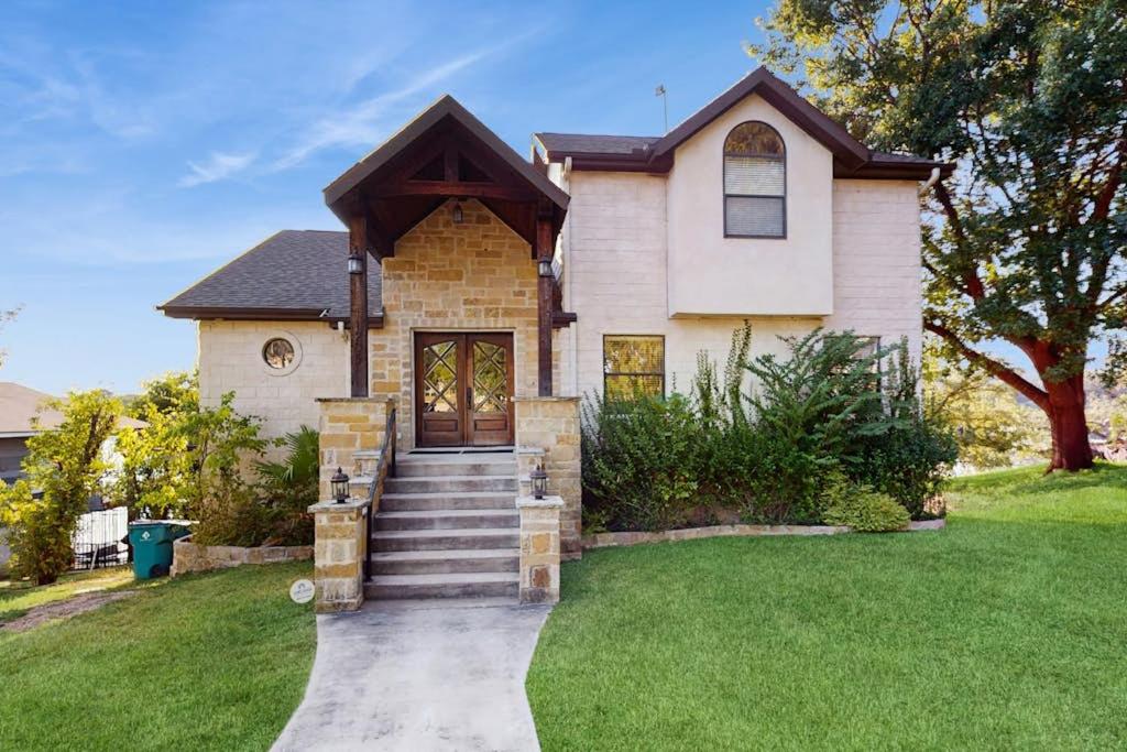 a house with a walkway leading to the front door at Opulent Waterfront Home with Dock, Firepit & Stunning River View in Burnet