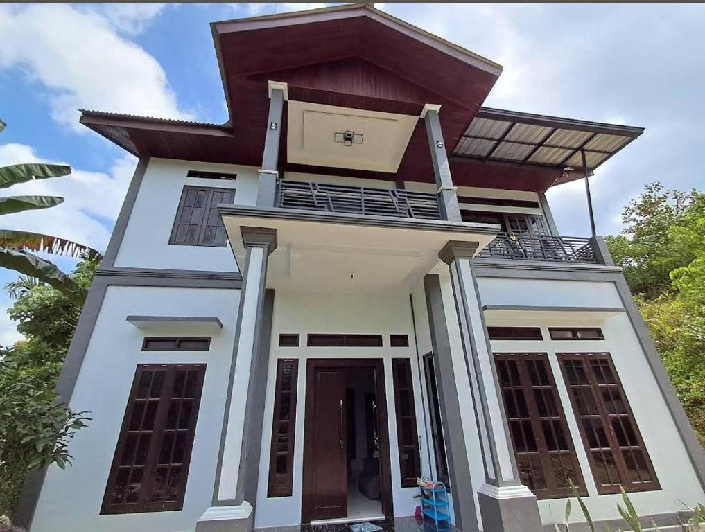 a house with a balcony on top of it at Raja Ampat Sandy Guest House in Saonek