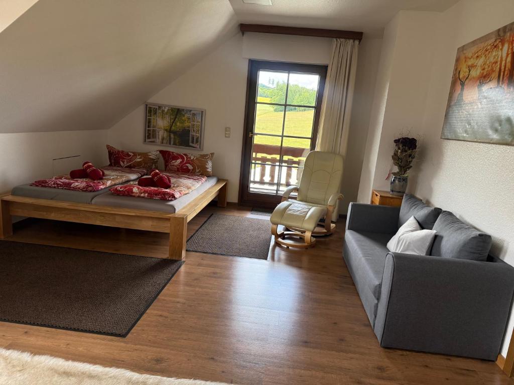 a living room with a bed and a couch at Ferienwohnung mit großem Balkon und Blick in den Taunus in Oberems