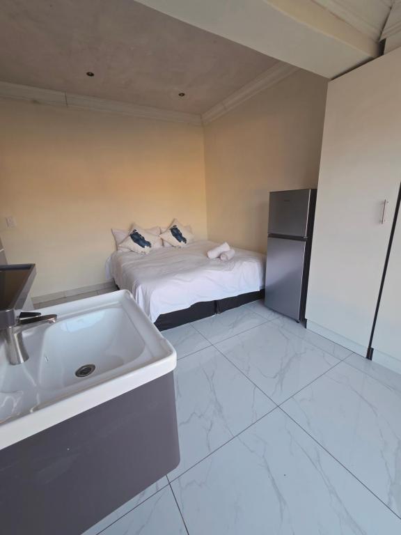 a bathroom with a bed and a sink and a tub at Mafjoint10 in eMalahleni