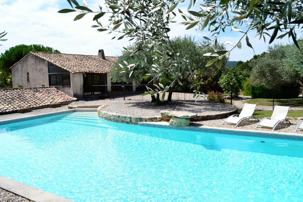 a swimming pool with chairs and a house at Auberge d'Anais in Entrechaux