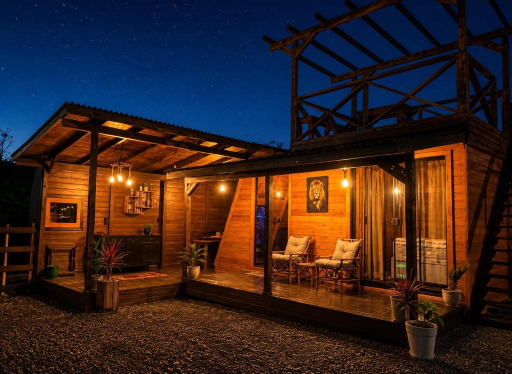 a wooden cabin with two chairs and a table at cabana ret in Alfredo Wagner