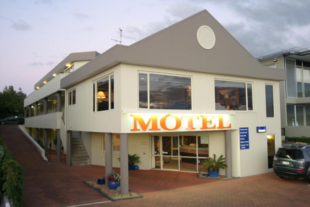 Baycourt Lakefront Motel في تاوبو: علامة الفندق على جانب المبنى