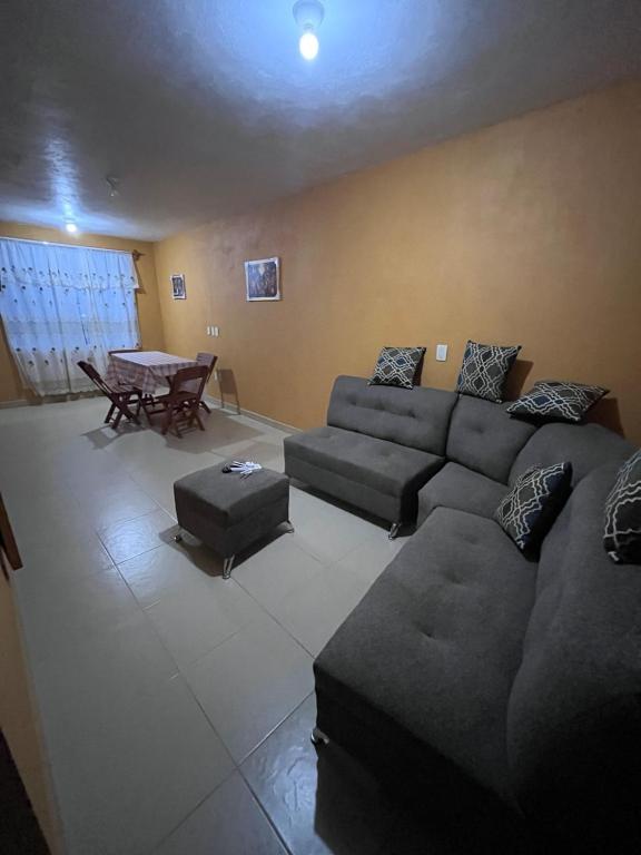 ein Wohnzimmer mit Sofa und Tisch in der Unterkunft Rincón acogedor in Toluca de Lerdo
