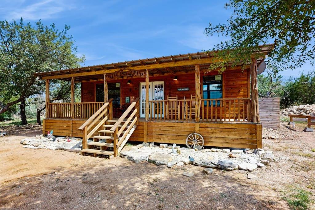 a log cabin with a porch and stairs to the front at Dog-Friendly Gem on 11 Acres with Valley Views, Deck, Gas Grill, Fireplace in Fredericksburg