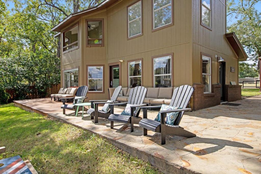 a group of chairs and a table in front of a house at Two-Story Waterfront Retreat with Boat Dock, Two Firepits & Two Kayaks in Burnet