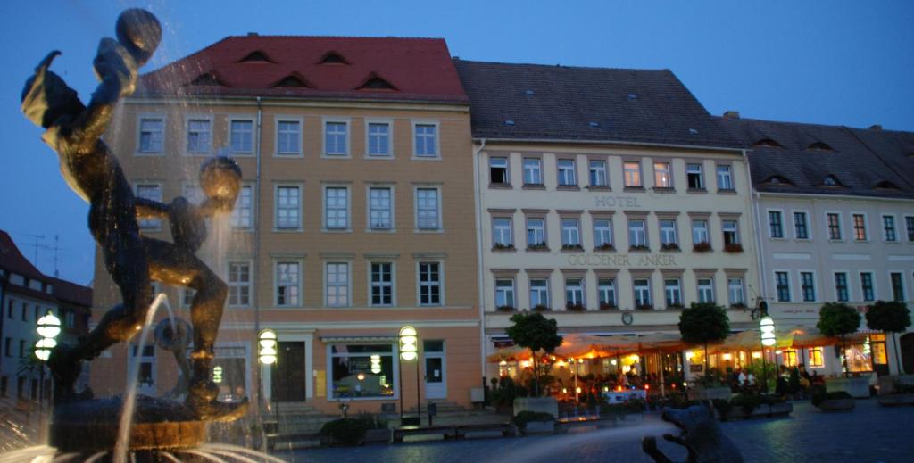 uma fonte em frente a um edifício numa cidade em Hotel Goldener Anker em Torgau