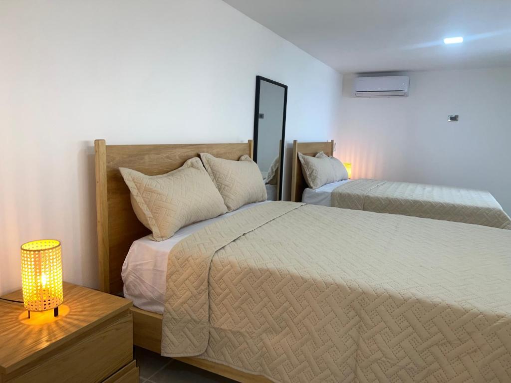 a bedroom with two beds and a table with a lamp at Santa Barbara River house in Santo Domingo
