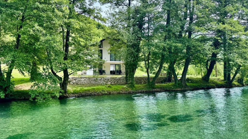 a house sitting on the side of a river at RiverHouse Tošinović in Šipovo