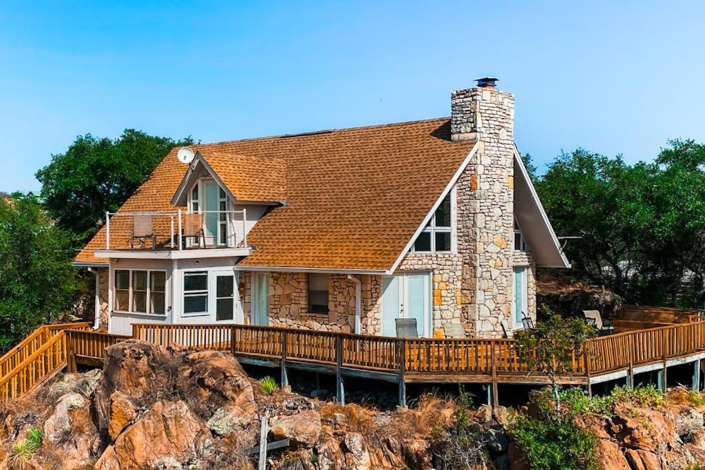 a house on top of a hill with a deck at Lovely 2-Story Home with Upper & Lower Decks, Gorgeous Lake & Hill Country Views in Burnet