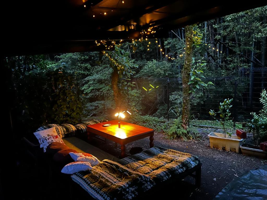 a couch with a table with a candle on it at Mitte Lodge 健やかな大人達の田舎ホームステイ1日1組限定で駅送迎と3食家庭料理体験付き in Atami