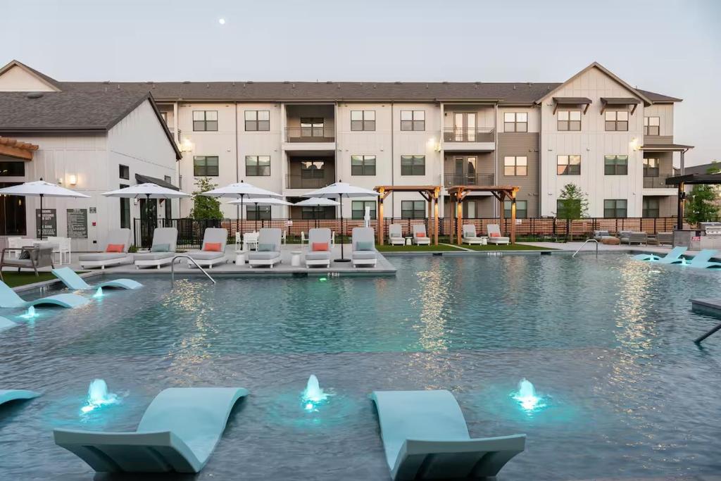 a swimming pool with lounge chairs and a hotel at Luxury 1bedroom 1bath Tech Hub in Austin